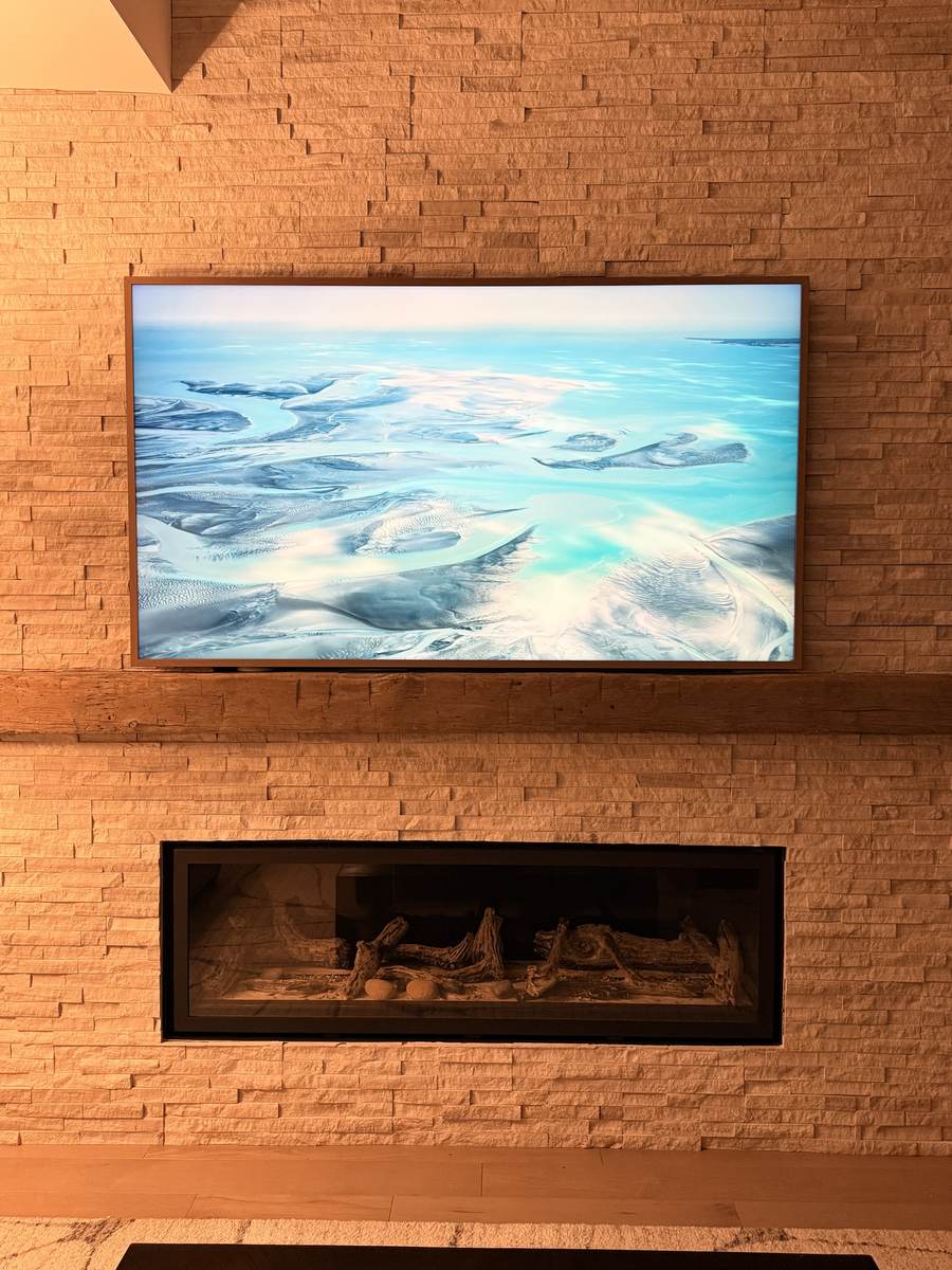 Frame TV on a stacked-stone fireplace wall
