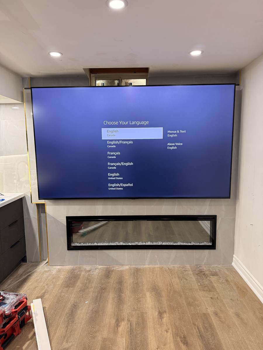 Large TV above a linear fireplace on a tiled wall